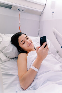 Female Patient In A Hospital Checking Her Phone.