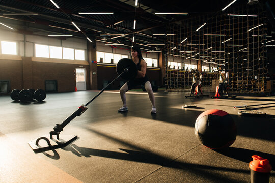 Strong and beautiful brunette crossfit athlete doing workout in a fancy gym