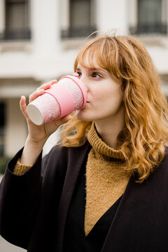Young Ginger Girl Drinking From A Reusable Coffee Mug