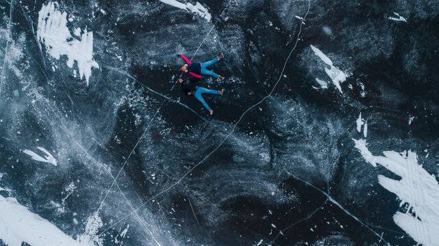 aerial view of a lovely couple in the middle of a frozen river