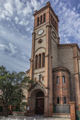 Fototapeta na wymiar Gothic style Catholic parish Saint Joseph Church. Like other monuments of city - statue of Saint Joseph located on its porch, as well as its bells are oldest in Perpignan. Pyrenees Orientales, France.