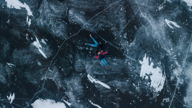 aerial view of a lovely couple in the middle of a frozen river