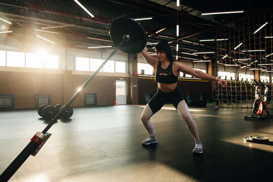 Strong and beautiful brunette crossfit athlete doing workout in a fancy gym