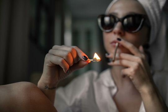 Close up portrait attractive woman smoking a cigarette at home