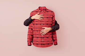 Two caucasian hands hands are wrapped around a pink patterned shirt