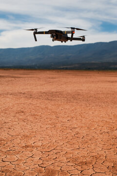 Black drone flying in arid desert