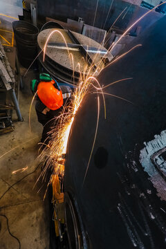 Worker at the factory polishing the metal tank