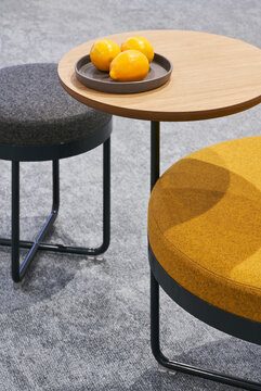 Soft poufs near table with lemons