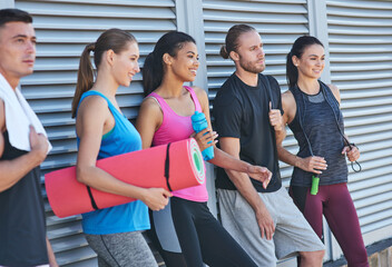 Young mixed race sportive people holding fitness equipment