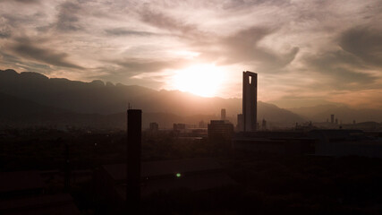 drone shot of a skyscraper against the Monterrey cityscape at the sunset
