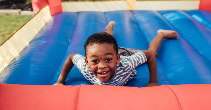 Young boy jumping outdoors in jump house
