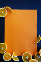 
On a black background, an orange sheet of paper, and on it
flat composition with sliced...