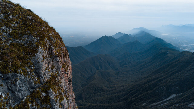 Cerra de la Silla drone view, misty mountain chain in the background and a rocky slope in front - Powered by Adobe