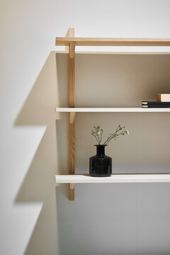 Vase with flowers and books on shelf