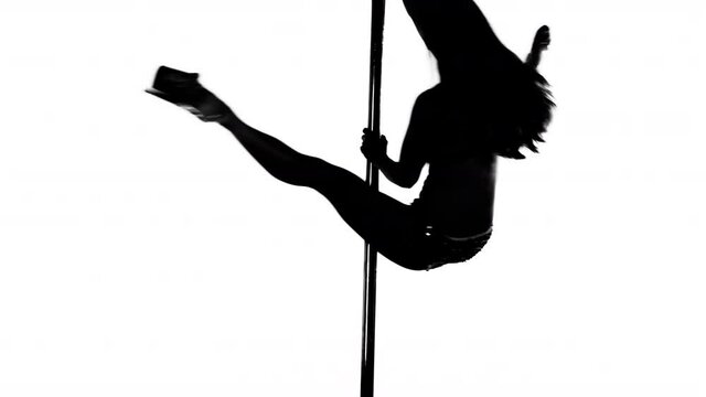 Pole dancer posing and dancing in studio