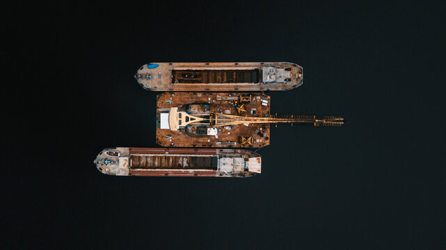 Floating crane at work. Loading empty cargos in the sea.