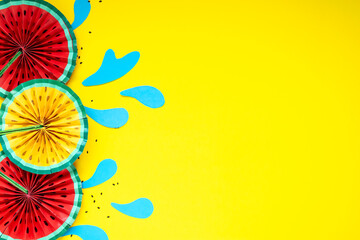Paper fruit origami watermelon fan decoration. Creative banner with copy space on bright yellow background. Tropics summer