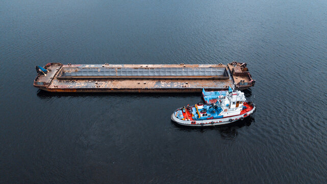Top-view of a small ship near the empty barge