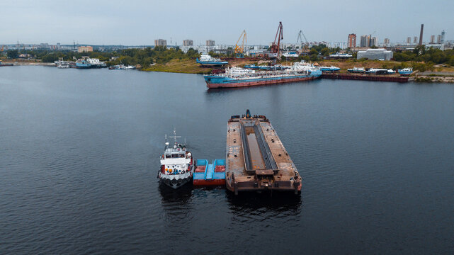 Top-view of a small ship near the empty barge