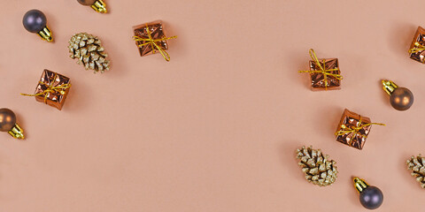 Christmas banner with fir cones, tree ornament baubles and gift boxes on brown background with...