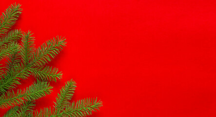 Christmas holidays composition fir branch on red background with copy space