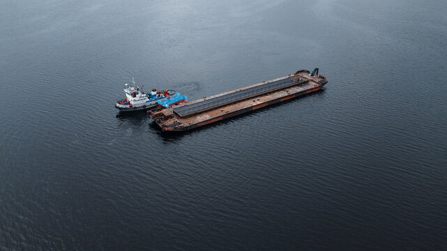 Top-view of a small ship near the empty barge