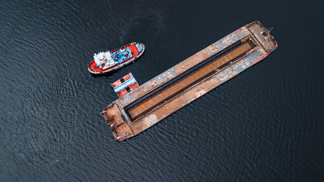 Top-view of a small ship near the empty barge