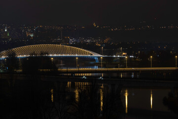 
view of street lighting on bridges on the Vltava river in the city of Prague at night and lights from passing cars