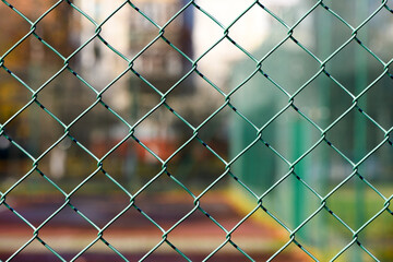 Fototapeta premium Mesh fence. Green metal fence made of welded mesh. Close up
