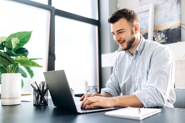 Online communication. Attractive caucasian guy communicates learns or works online via video...