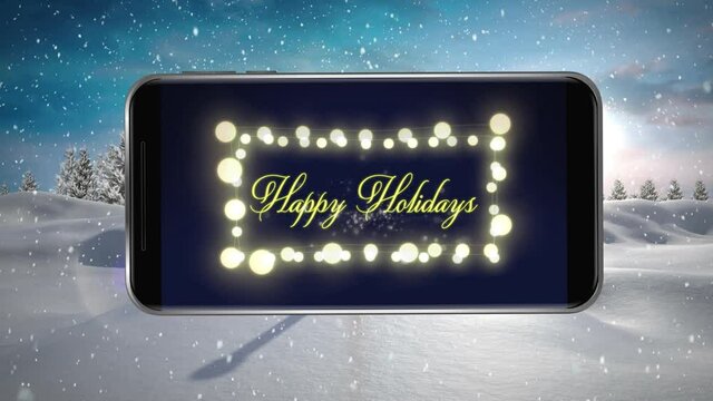 Animation of happy holidays text and fairy lights displayed on smartphone screen with winter scenery
