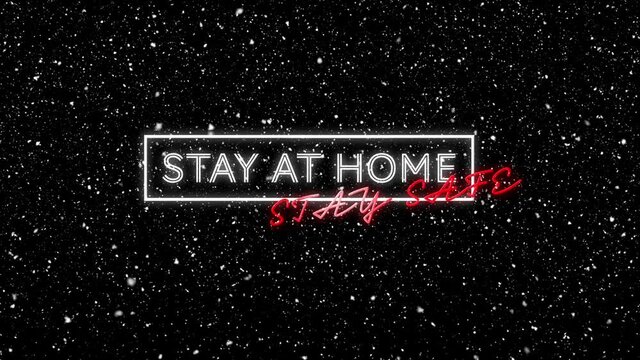 Animation of stay at home stay safe text with winter scenery and snow falling on black background