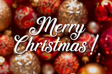 Christmas wishing handwritten card. White Merry Christmas sign on blurred bokeh decorative balls background. Congratulations, holidays, celebration, greeting. Red and gold. Ready to use, print