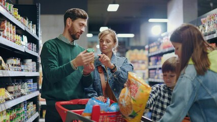 Young beautiful friendly family with kids searching goods on food shopping shelves grocery store organic marketplace supermarket together concept.