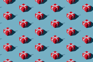 Christmas isometric pattern, background, banner. Minimal composition made of Christmas red gift box on a blue background. Top view. Holiday New Year concept. Xmas presents, congratulations