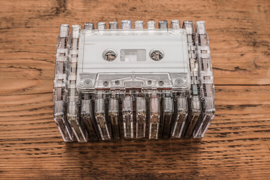 background of Gray transparent stack compact Cassette tapes over old retro vintage aged wooden table texture. top view backdrop .Idea of audio book