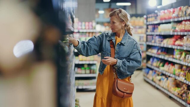 Beautiful happy parents and cute two kids searching foods on grocery store supermarket shopping products together enjoying nice day weekend together.