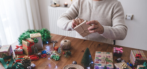 man doing gift wrapping christmas concept with do-it-yourself craftsmanship