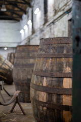 Old porto lodge with rows of oak wooden casks for slow aging of fortified ruby or tawny porto wine in Vila Nova de Gaia, Portugal