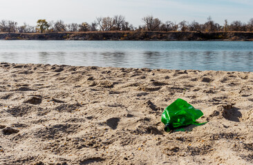 Plastic trash on the river beach closeup. World pollution problem