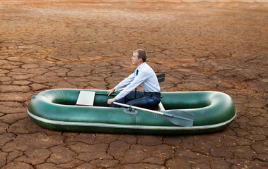 man will rows home for shore in paddle powered row boat businessman in boat rocks looks bright...