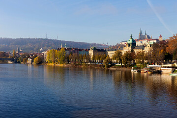 Autumn colorful Prague Lesser Town with gothic Castle above River Vltava in the sunny Day, Czech Republic