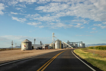 Grain silos on a roadside farm as seen from drivers perspective © Cavan
