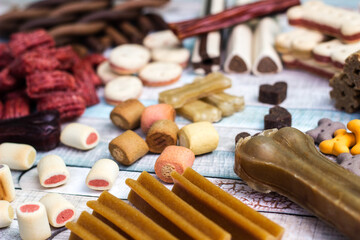Pet food, snacks for dogs. Dog tasty colored biscuits on wooden background.
