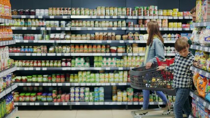 In supermarket grocery store young happy family kids and parents walking through sections choosing food products talking together having fun on weekend. - Powered by Adobe