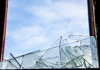  background of broken debris glass in window wooden frame backdrop against blue sky with clouds