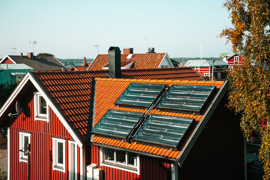 Traditional Swedish red house with solar panels on the roof