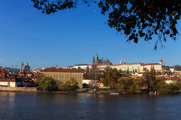 Autumn colorful Prague Lesser Town with gothic Castle above River Vltava in the sunny Day, Czech Republic