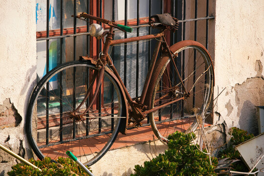 A photo of a rusty vintage bicycle inside a derelict house.