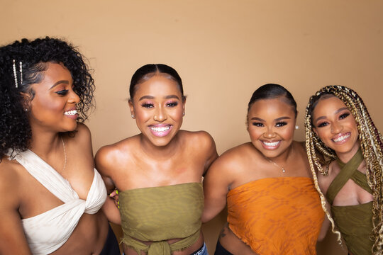 Studio portrait of four happy beautiful black female friends